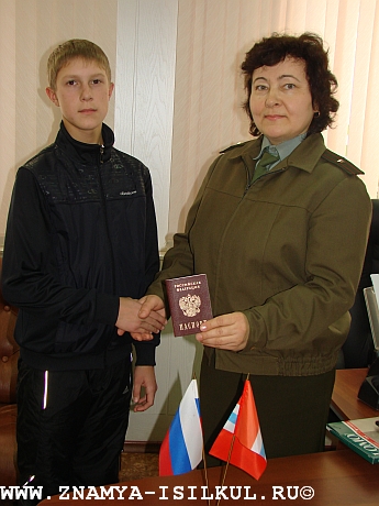 Начальник отдела УФМС России по Омской области в Исилькульском районе, майор внутренней службы Л.П. Сивцова вручает паспорт гражданина РФ Роману Викторенко, ученику 8А класса средней школы №1.